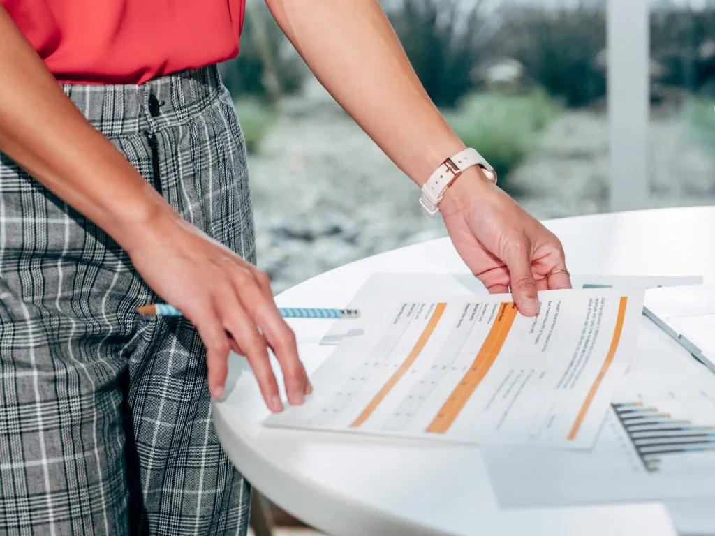 Woman in Red Holding Accounting Papers